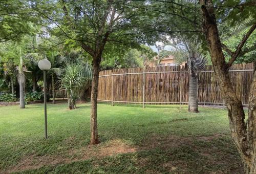 a fence in a yard with a tree and a street light at Suikerbosrant Sleep and go in Pretoria