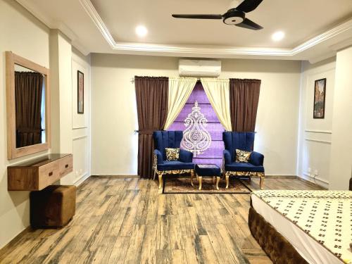 a bedroom with two blue chairs and a bed at Executive Apartments In Bahria Heights in Rawalpindi