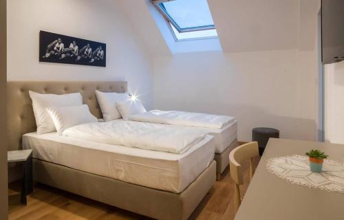 a bedroom with a bed and a table and a window at Hotel Belmur in Murska Sobota
