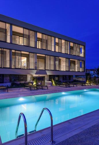 a swimming pool in front of a building at night at ANASSA BUTIK LIVING NIKITI in Nikiti
