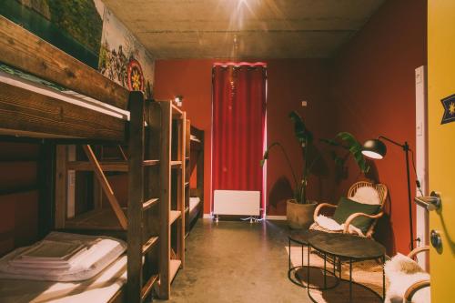 クノック・ヘイストにあるLakeside Paradise Sport Hostelの二段ベッドと赤いカーテンが備わる客室です。