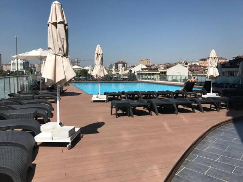 a group of tables and umbrellas next to a pool at Panoramic scenery, Pool, Turkish Bath, Sauna, Gym, 3BRoom,1 Living Room 2Bathroom and Much More in Istanbul
