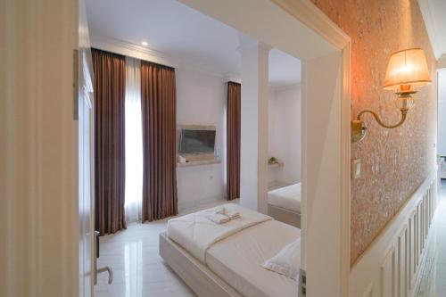 PangkajeneにあるWisma D’King RedPartnerのベッドとテレビが備わるホテルルームです。