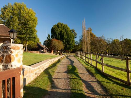a fence next to a field with a road at Whispering Waters in Fort Nottingham