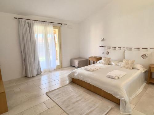 a bedroom with a large bed and a large window at Pedra Smeralda in Golfo Aranci