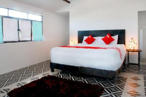 - une chambre avec un grand lit et des oreillers rouges dans l'établissement OYO Hotel Maria Otilia Falla, Papantla, à Papantla