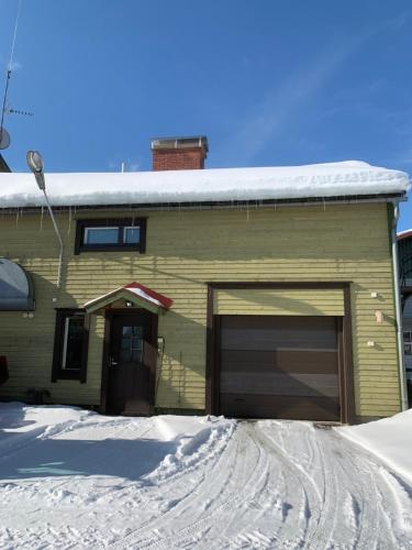 een huis met een garage in de sneeuw bij Majoitus Ilomantsissa in Ilomantsi