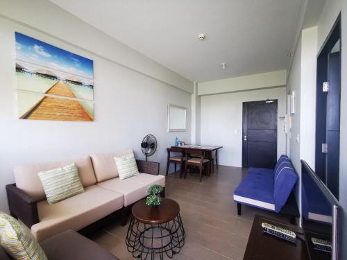 uma sala de estar com um sofá e uma mesa em New Paradise Ocean View Apartment (DOT accredited) em Boracay