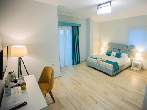 um quarto com uma cama e uma secretária num quarto em Marbella Beach Hotel em Golem