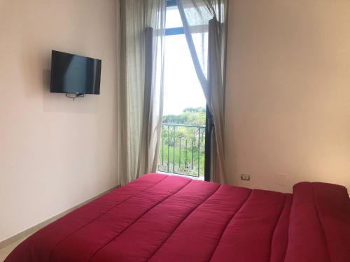 um quarto com uma cama vermelha e uma janela em Casa Dalila em Vietri