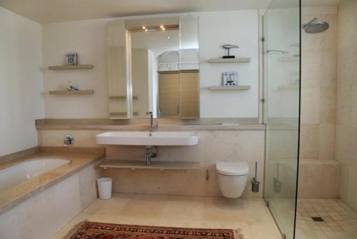 a bathroom with a sink and a tub and a toilet at Knight's House in Hermanus