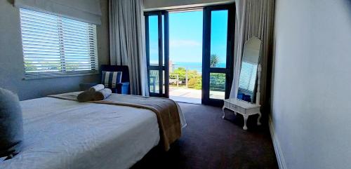 a bedroom with a bed and a view of the ocean at Knight's House in Hermanus