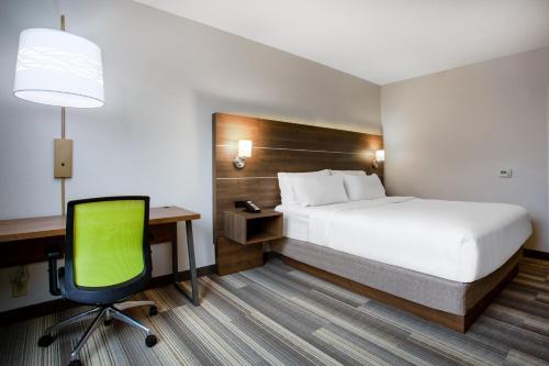 a hotel room with a bed and a desk and a chair at Holiday Inn Express Hotel & Suites Fort Wayne by IHG in Fort Wayne