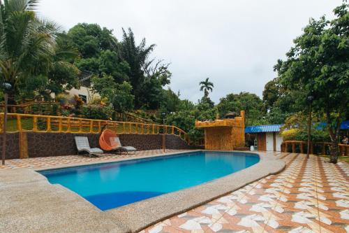 una piscina en un patio trasero con una valla en Rainbow Forest Paradise Resort and Camping Area by Cocotel en Rizal