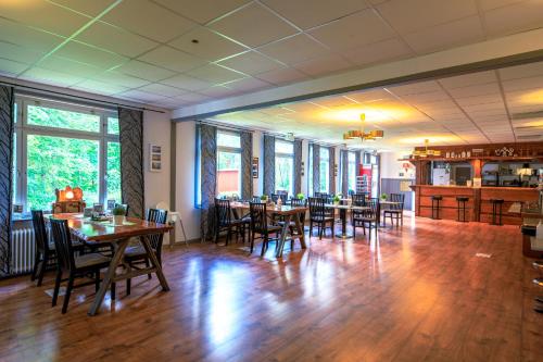 une salle à manger avec des tables et des chaises en bois dans l'établissement Brukshotellet Skinnsberg, à Skinnskatteberg