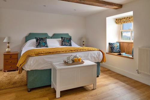 Un dormitorio con una cama y una mesa con velas. en Finest Retreats - Moelis Granary - Luxury Cottage with Hot Tub en Llandrillo