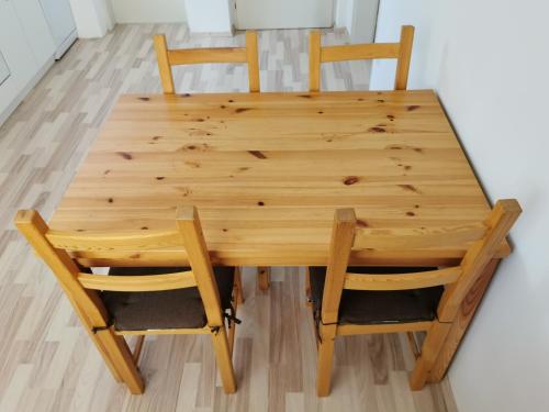 ein Holztisch mit vier Stühlen um ihn herum in der Unterkunft Apartments Henigman in Bohinj
