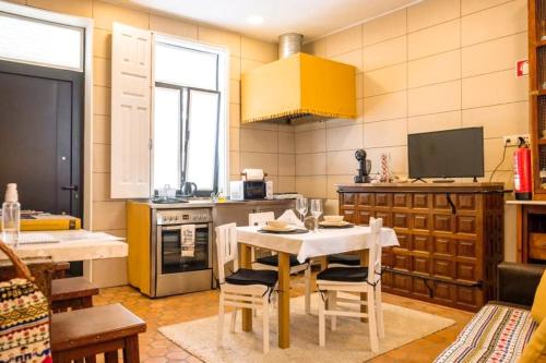 a kitchen with a white table and chairs in a kitchen at Casa dos Sequeiras Port Wine Cellars in Vila Nova de Gaia