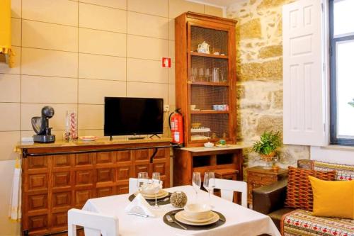 a living room with a table and a tv at Casa dos Sequeiras Port Wine Cellars in Vila Nova de Gaia
