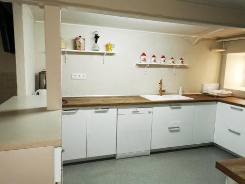 a kitchen with white cabinets and a sink at Casa El Jazmín in Anguciana