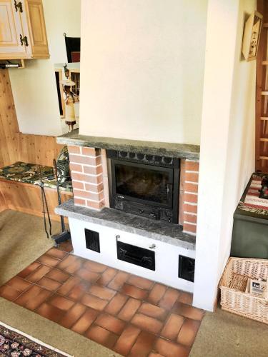 a fireplace in a living room with a brick fireplace at Mimöseli in Schwarzsee