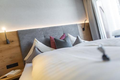 a bedroom with a large bed with pillows at Aparthotel Hochland GmbH in Nauders