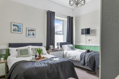 una camera con due letti e uno specchio di Wayfarer Guest House a Torquay