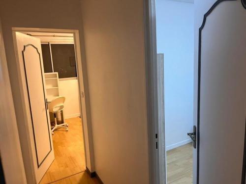 een open deur naar een kamer met een stoel bij Superbe appartement avec magnifique vue sur Paris in Sucy-en-Brie
