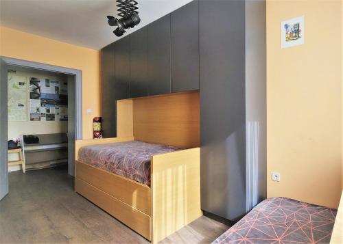 a bedroom with a bed with a wooden headboard at Central View Apartment in Pristina