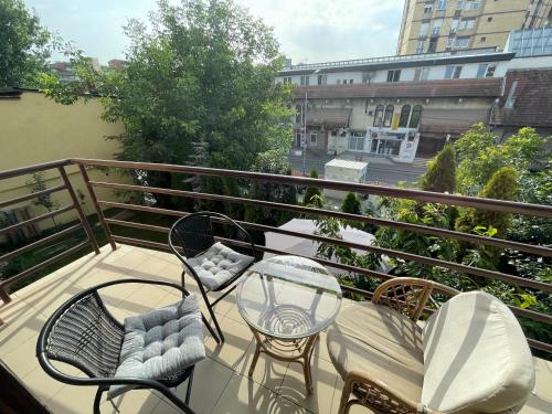a balcony with chairs and a table on a balcony at Huge Apartment with a Garden in the City Center in Pristina