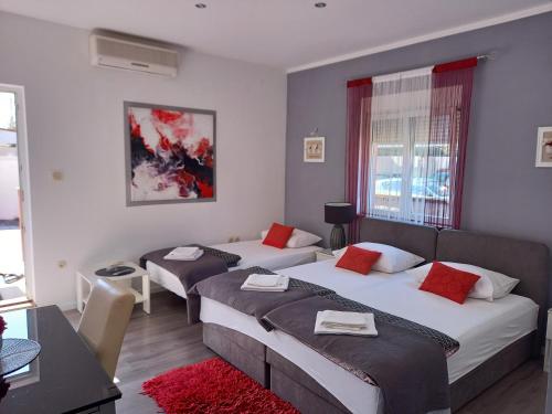 a hotel room with two beds and a couch at Apartments Benic with a heated pool in Zadar