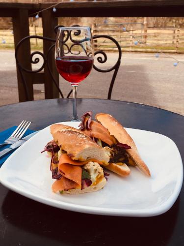 a sandwich on a white plate with a glass of wine at Whitebridge Hotel in Whitebridge