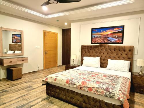 a bedroom with a large bed and a mirror at Executive Apartments In Bahria Heights in Rawalpindi