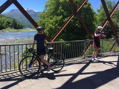 two women standing on a bridge with a bike at Au Primerose Hôtel in Argelès-Gazost