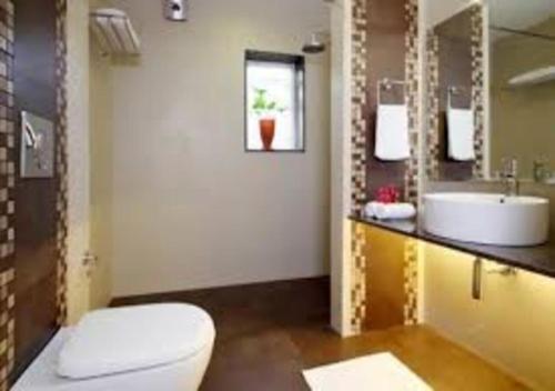 a bathroom with a toilet and a sink at SWISS COUNTY in Idukki