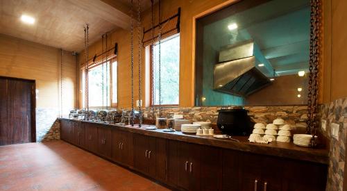 una cucina con un lungo bancone in una stanza di Rega Tuskar's Riverside Resort Jim Corbett a Ramnagar