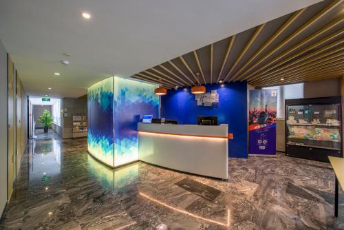 a lobby of a hotel with blue walls and a counter at Holiday Inn Express Foshan Chancheng by IHG in Foshan