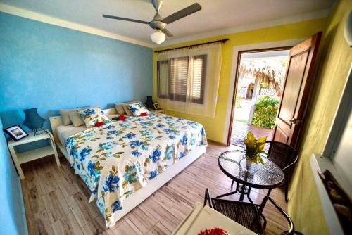 1 dormitorio con cama, mesa y puerta en Casa Azul Las Galeras, en Las Galeras