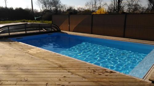 una piscina con terraza de madera y agua azul en Gîte avec piscine ,près de Chantonnay, en Saint-Germain-de-Prinçay
