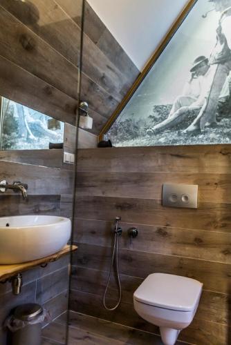a bathroom with a sink and a toilet and a mirror at Domki Karpielówka Luxury Chalet in Kościelisko