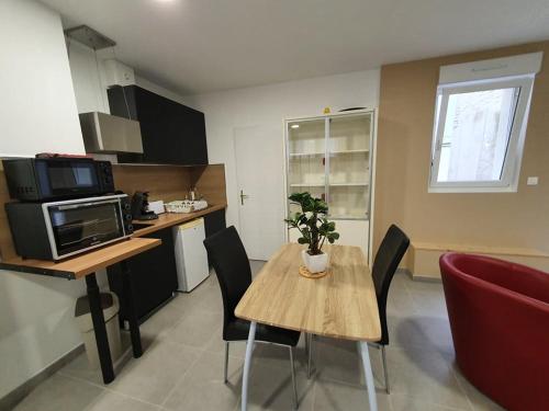 une cuisine avec une table et des chaises dans une cuisine dans l'établissement Grand studio Gravelines centre , 5 mn du cnpe et de la plage, absence de chambre privative, à Gravelines