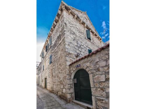 an old stone building with a door on a street at Apartment Primosten Center in Primošten