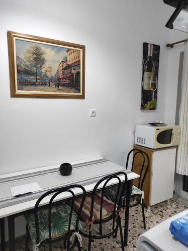 una mesa y sillas en una habitación con un cuadro en la pared en KROKOS HOUSE, en Aliveri