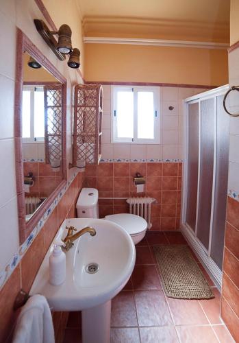 a bathroom with a sink and a toilet and a mirror at Cortijo de Frías in Cabra
