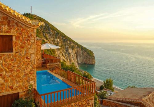 a house with a swimming pool next to the ocean at Beyond Villas in Agios Nikitas