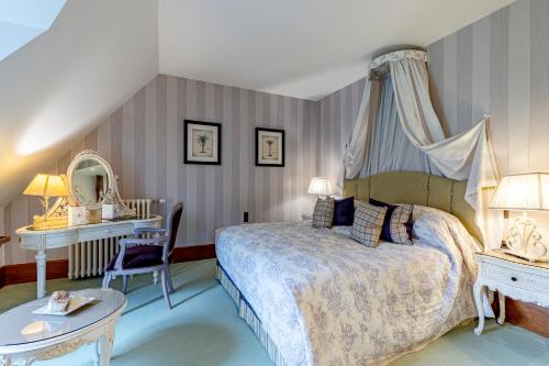 a bedroom with a bed and a table and a mirror at Abbaye de la Bussière in La Bussière-sur-Ouche