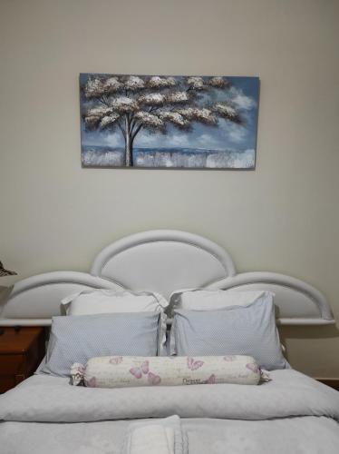 a bed with two pillows and a painting on the wall at KROKOS HOUSE in Aliveri