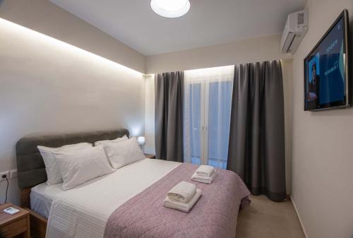een slaapkamer met een bed met twee handdoeken erop bij Luxury Apartment Marine View in Agios Nikolaos
