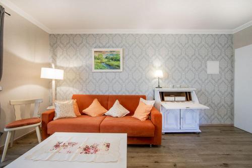 - un salon avec un canapé orange et une table dans l'établissement Landgasthaus Zum Kreuzberg, à Schönbach