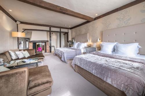 a large bedroom with two beds and a couch at The Great House Lavenham Hotel & Restaurant in Lavenham